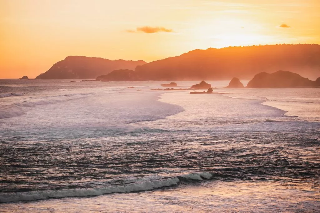 sunset-landscape-with-huge-waves-and-mountain-hills-on-horizon-golden-yellow-and-orange-colors-1024x682.jpg